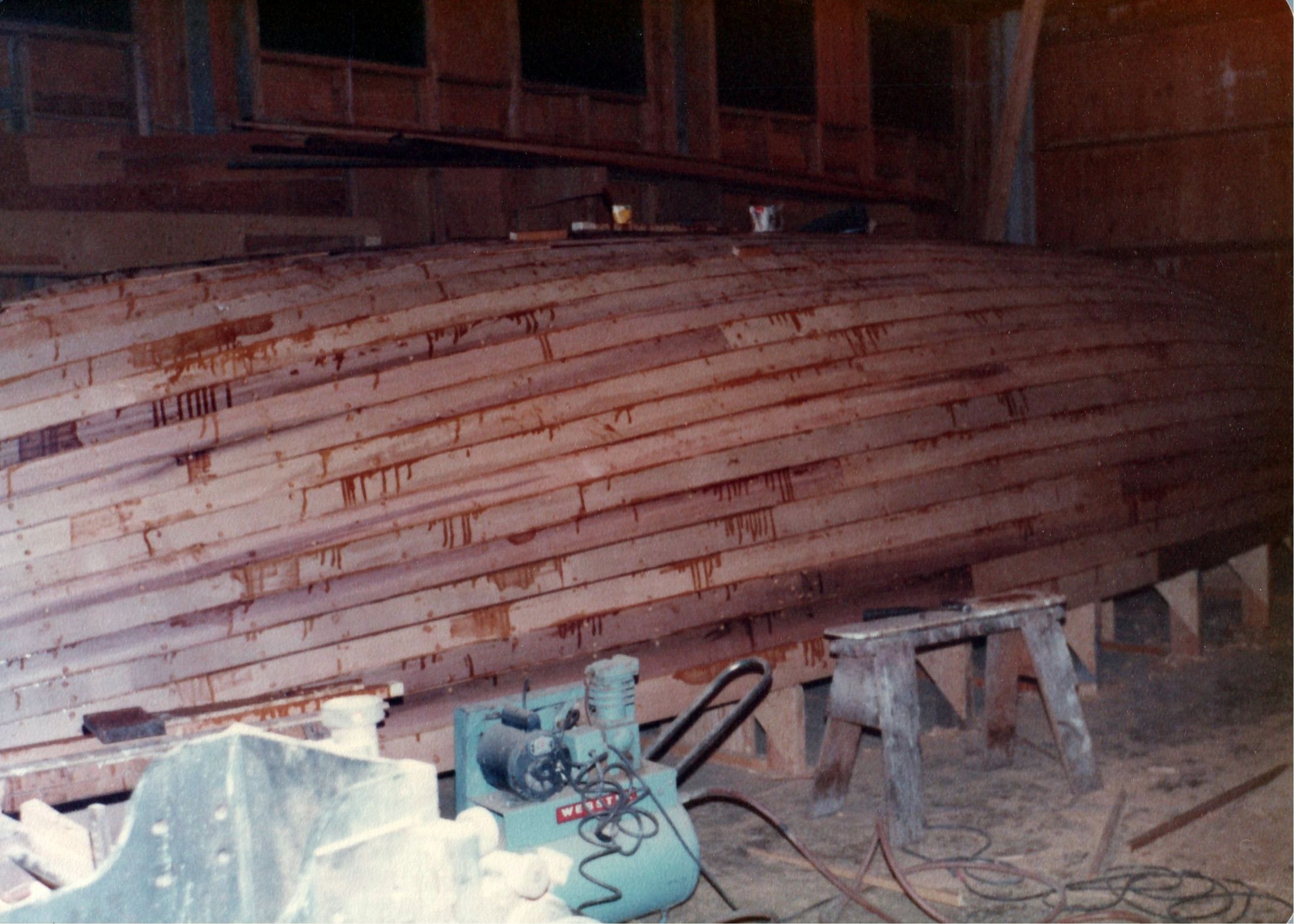 The planked hull along its length, a power plane on the bench