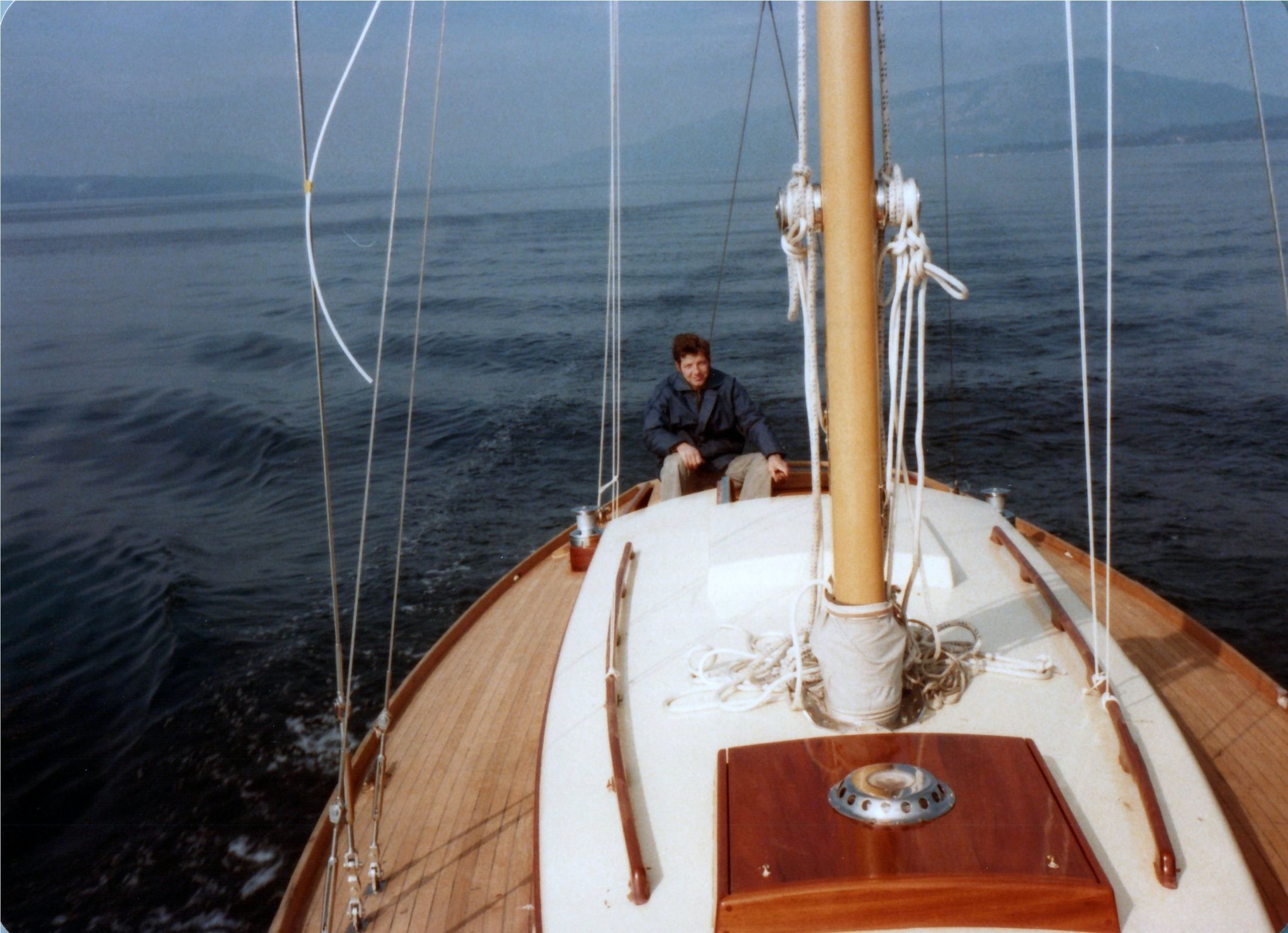 From the masthead side: the foredeck under way, the helmsman aft